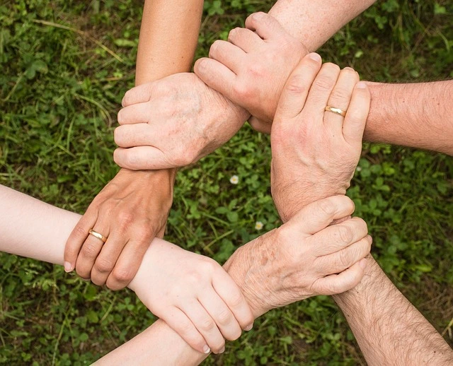 A circle of people holding hands. Stronger community connections. Localized content helps you connect with your audience on a more personal level.